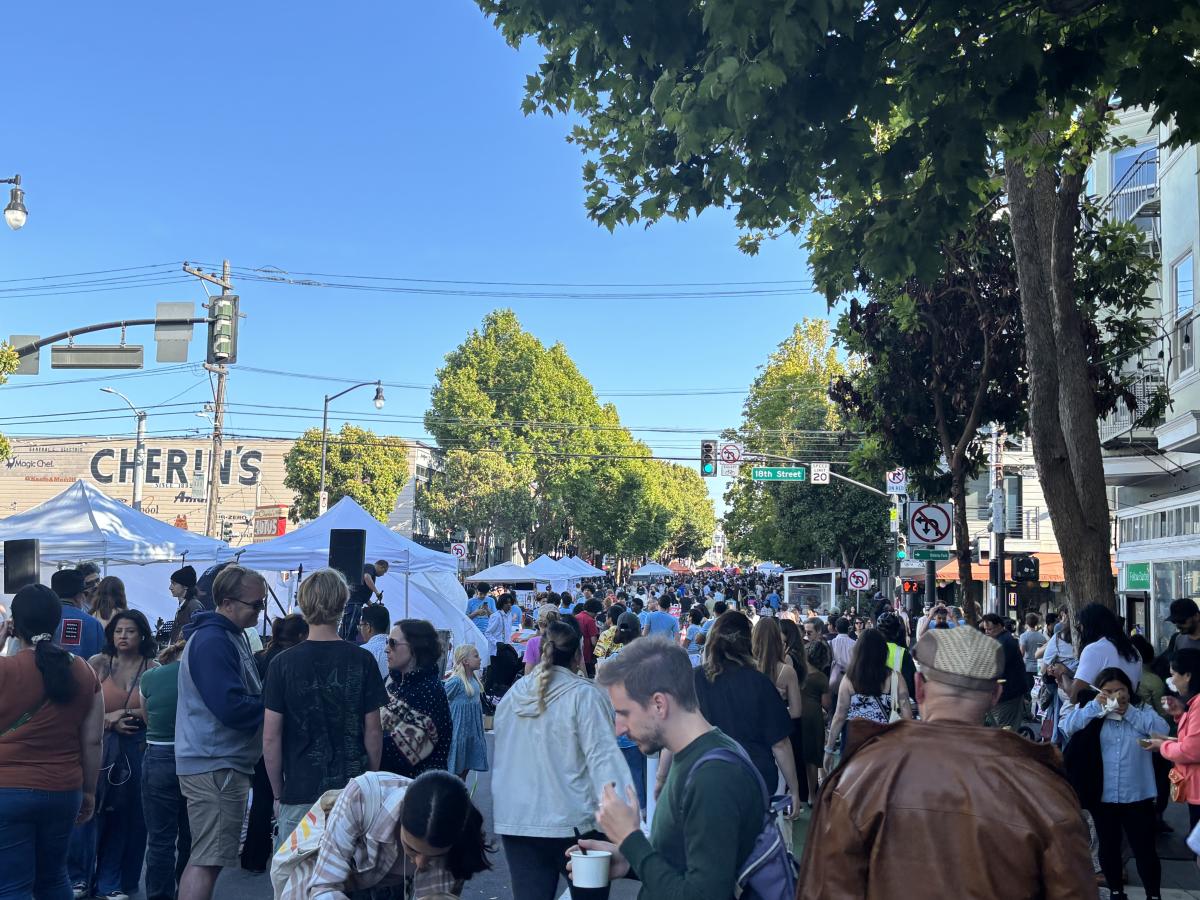 People in a street with event tents.