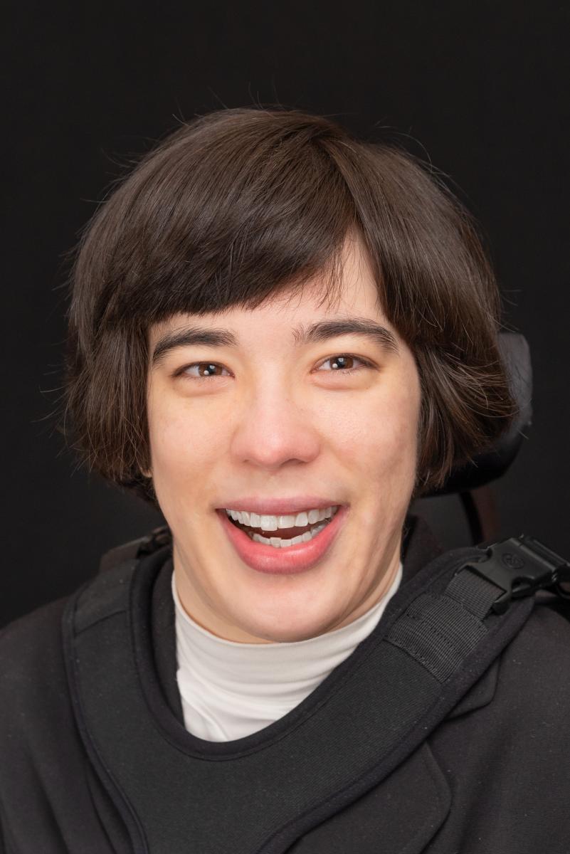 Director Hinze Director Hinze, a White woman, is pictured smiling against a black backdrop. She wear a white turtlenech under a black top.