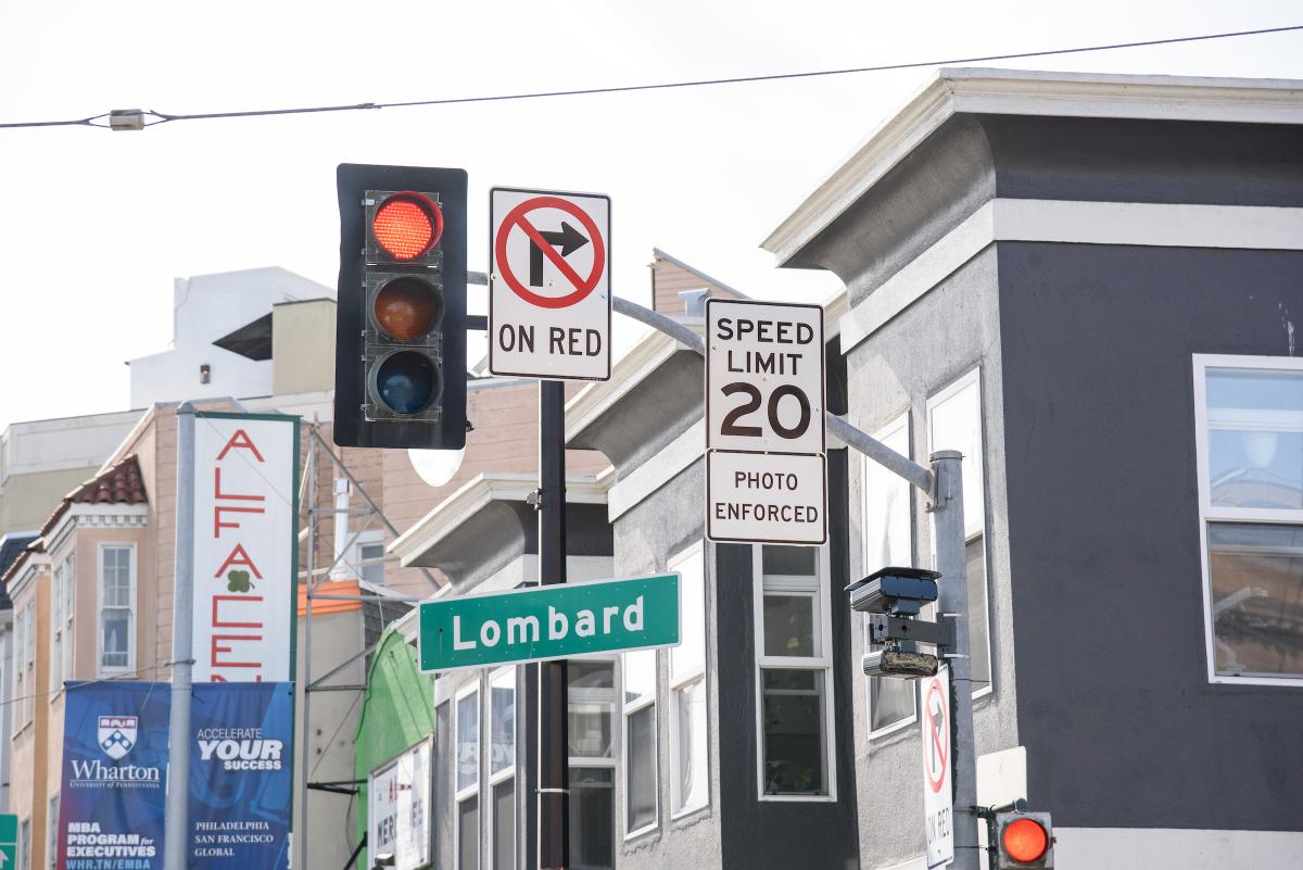 Speed camera seen in close up near signs that refer to speed limits and Lombard Street.