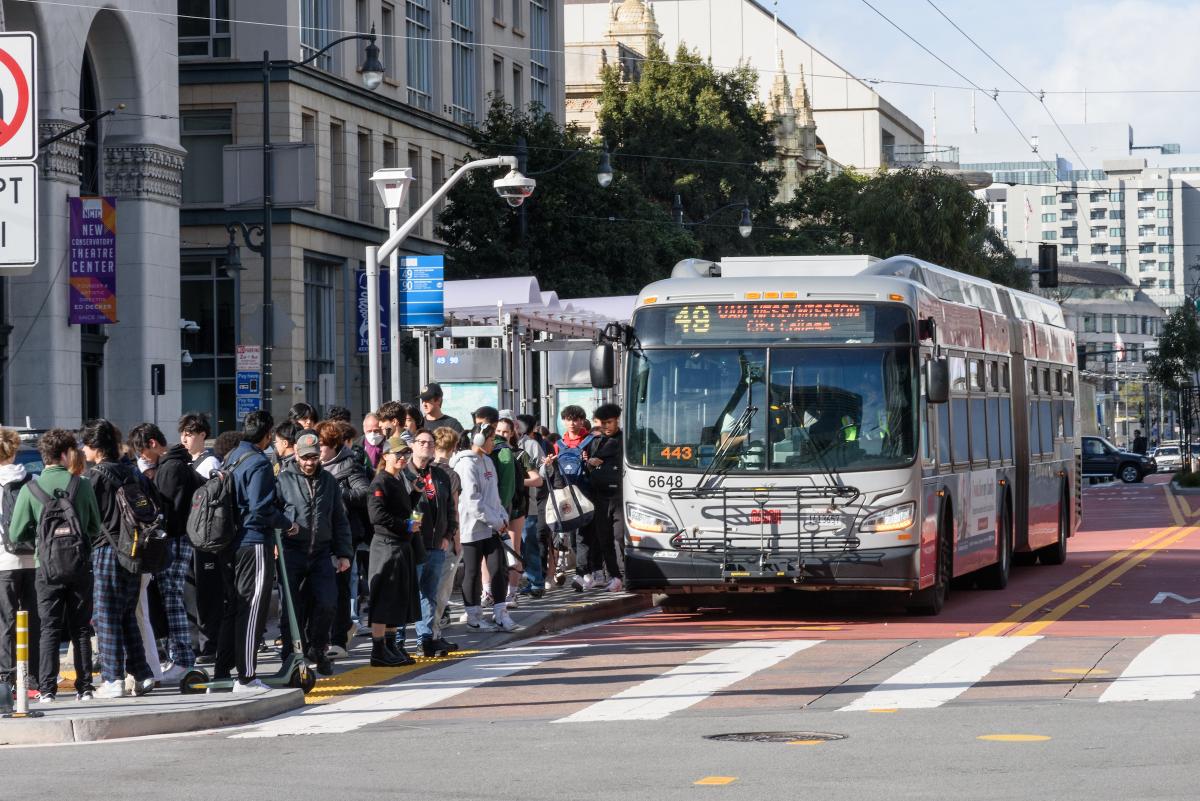 A bus at a crowded stop.