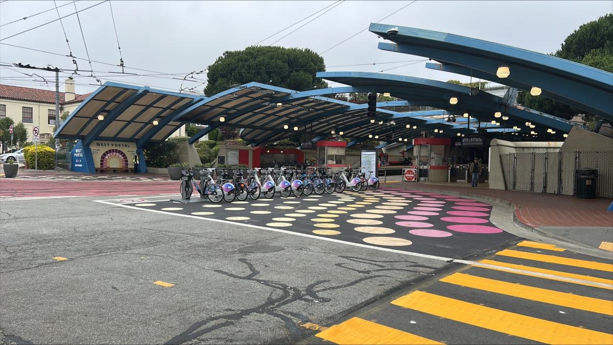 Outside of West Portal Station, a new bikeshare station is filled with bikes.