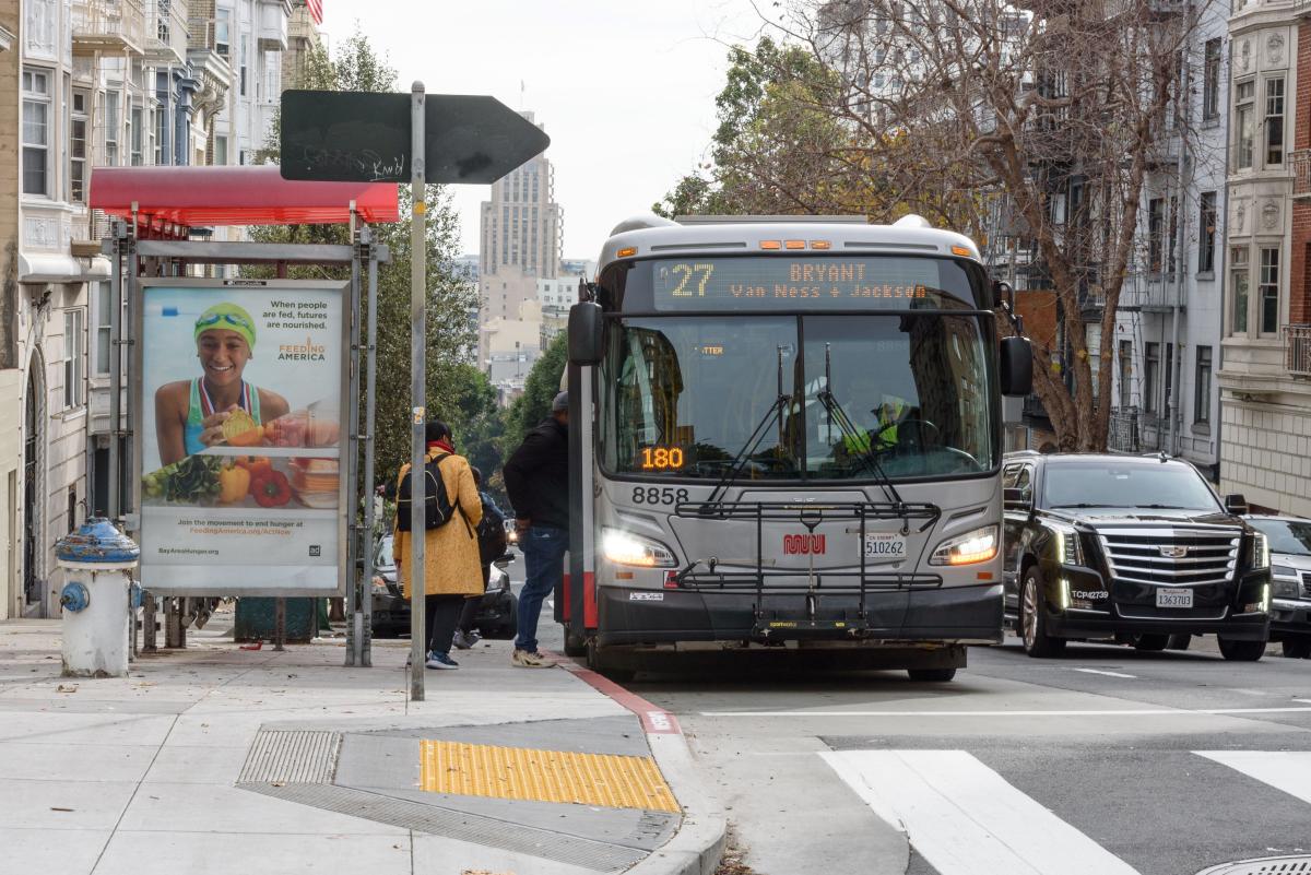 People board a 27 Bryant bus near a bus shelter.