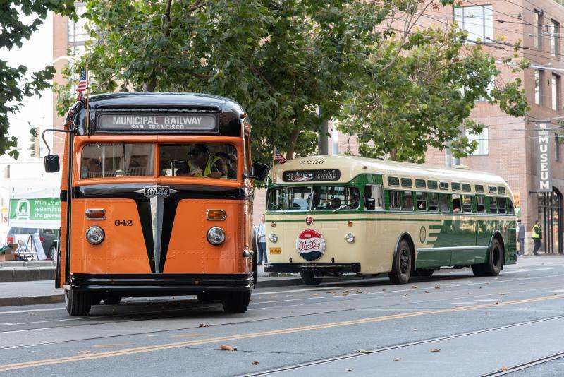 Two vintage Muni buses head toward Market Street during last year's Muni Heritage Weekend.