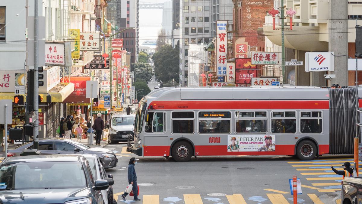 30 Stockton bus drives through Chinatown with many signs for small businesses in the background.