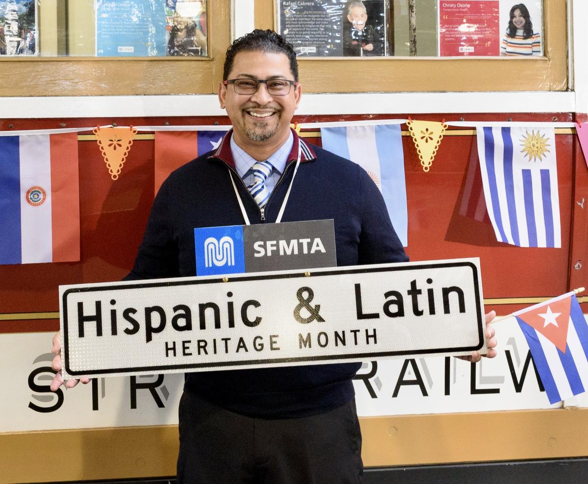 A person holding a sign in front of some decorations. 