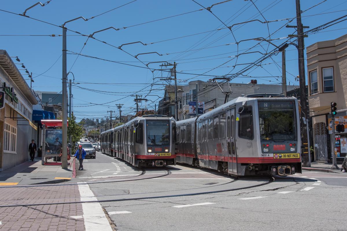 Two Breda light rail vehicles next to each other on tracks.