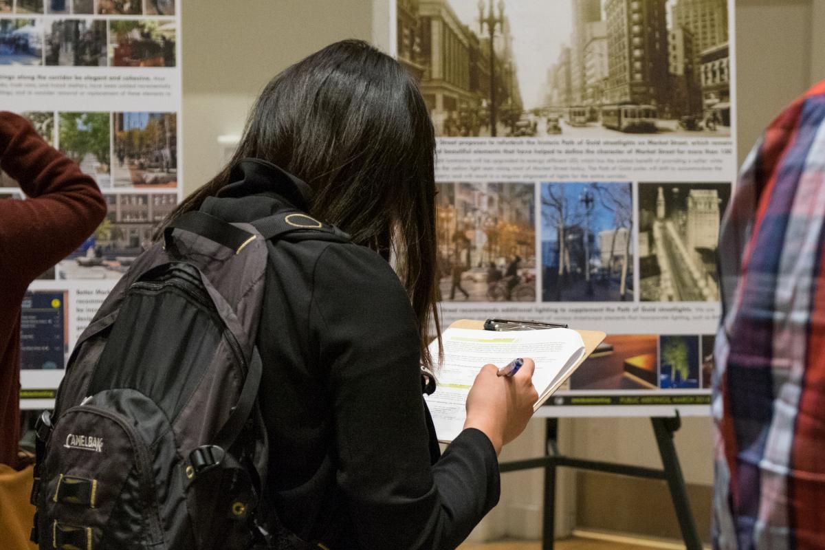 Person writes on a clipboard to take an SFMTA survey.