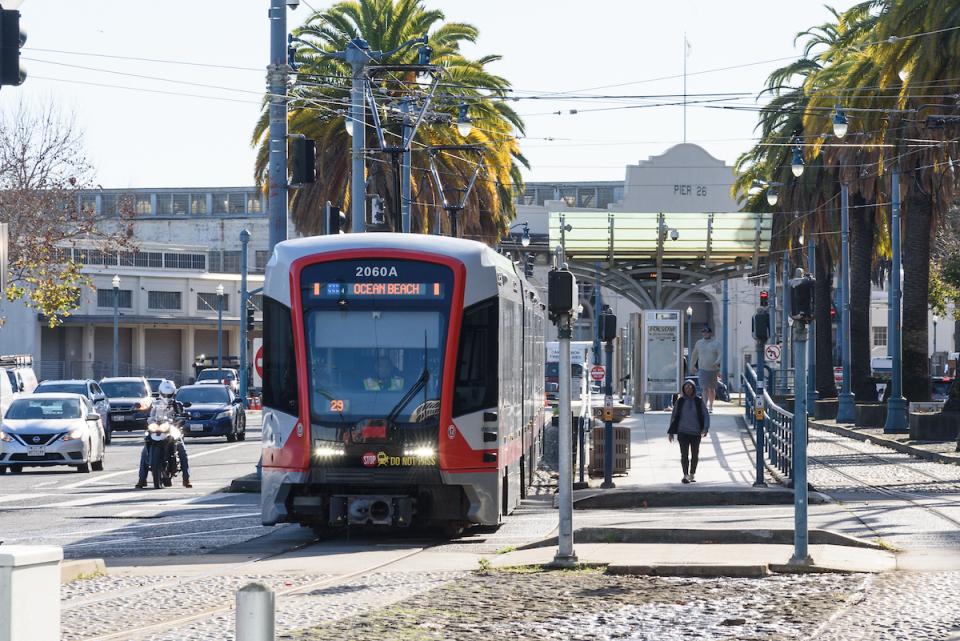 A photo of the N Judah on the Embarcadero with Pier 26 in the background.