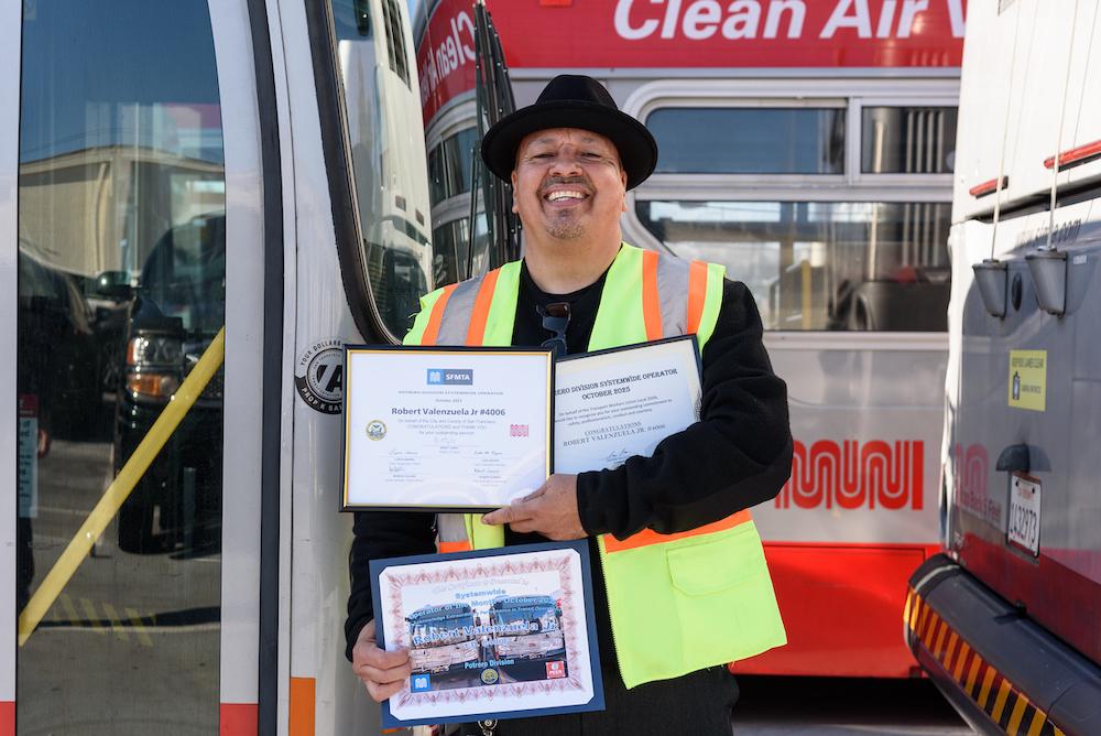 Photo of Muni operator holding certificates. 