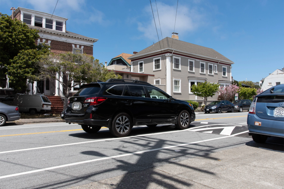 A vehicle drives toward a traffic calming device. 
