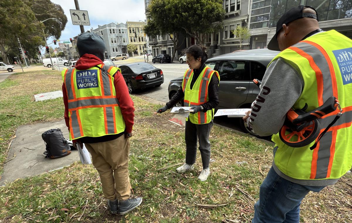 Image of Public Works and SFMTA staff planning work in the field at the Oak & Masonic intersection