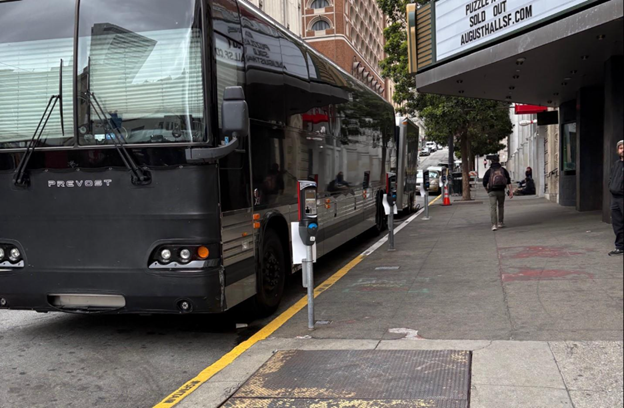 A black shuttle is parked outside of an entertainment venue.