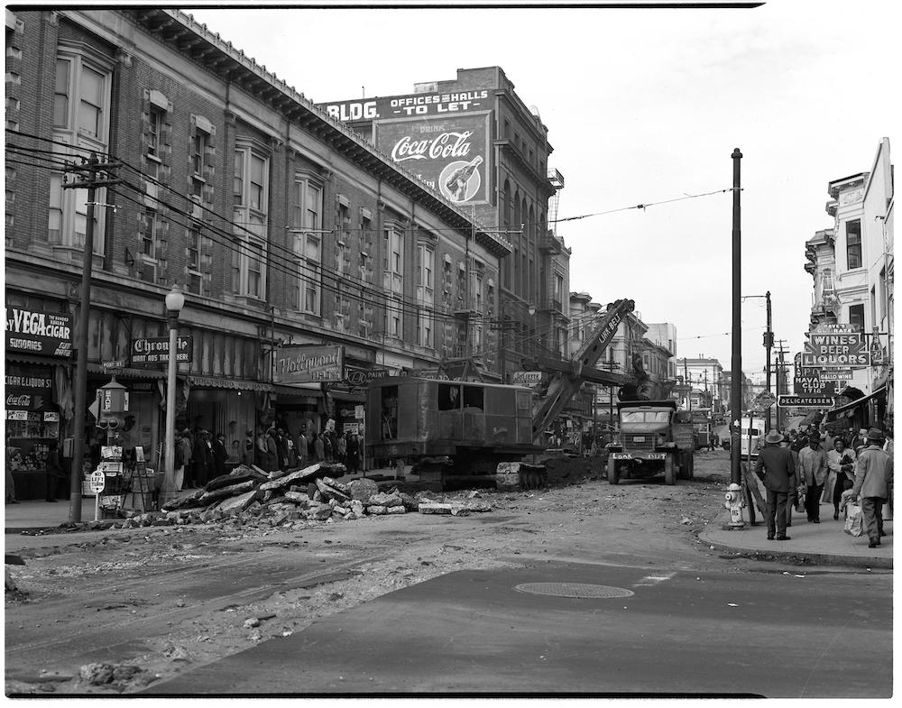 Black and white photo showing streetcar tracks being removed for the 22 Fillmore. Image of Fillmore and Post streets.