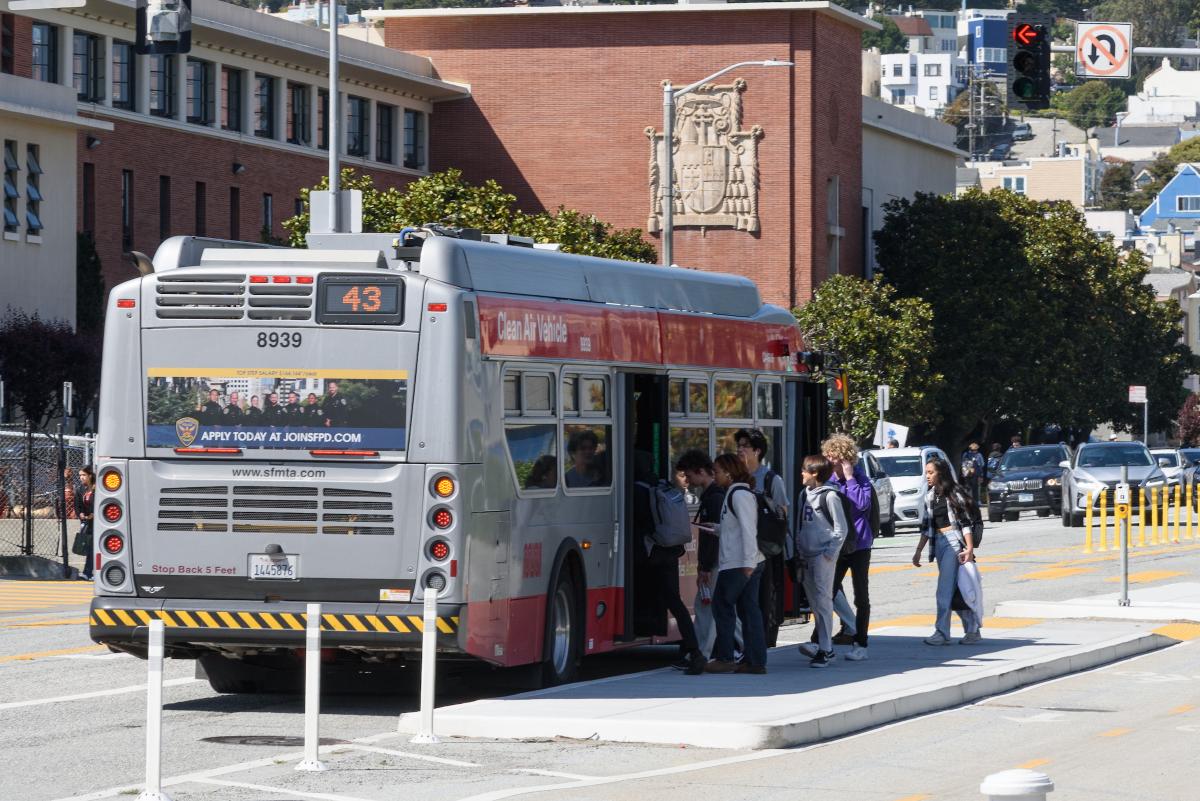 Several young people board a 43 Masonic. 