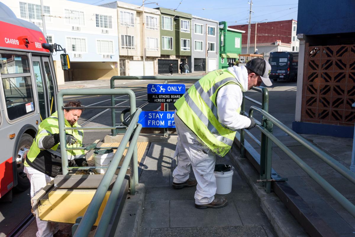 SFMTA crews paint and make other upgrades to a boarding island.