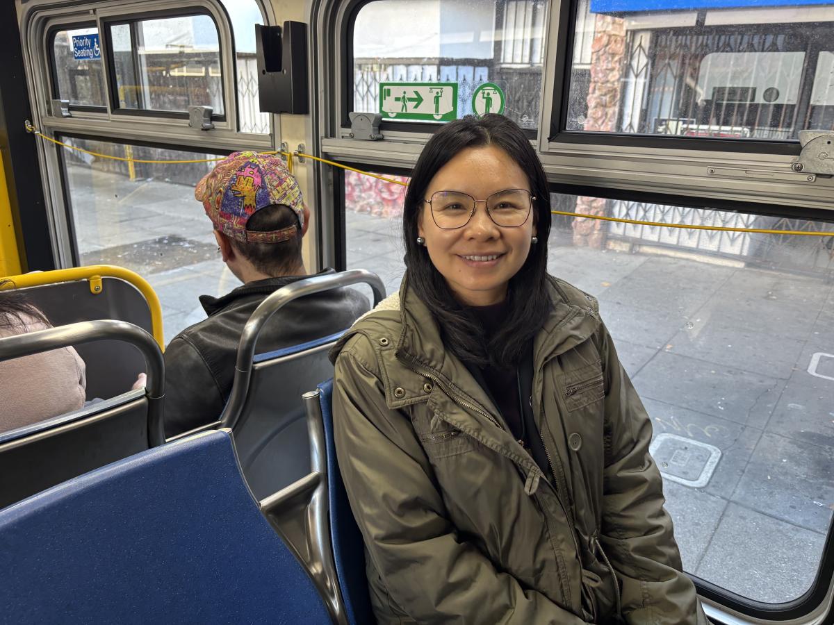 A person sitting next to a window on a bus.
