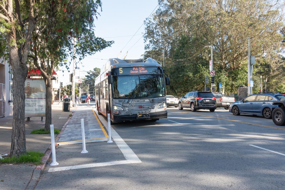 A 5 Fulton bus approaches a stop near Golden Gate Park.