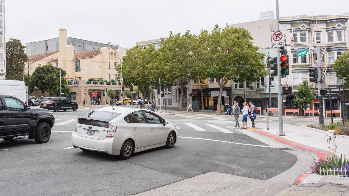 A car stops at a limit line ahead of a crosswalk.