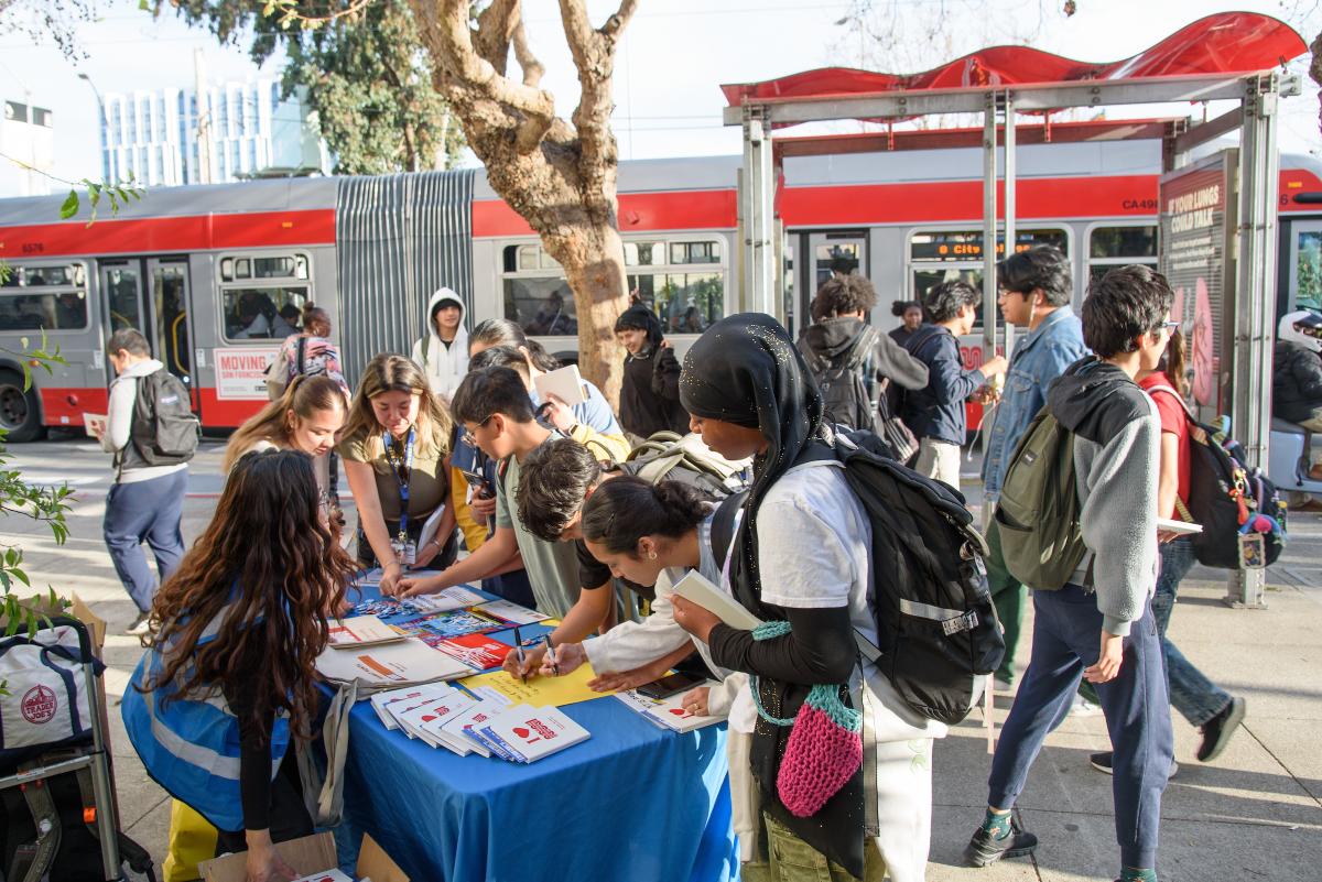 Several students stop by a table for a Safe Routes to School event.