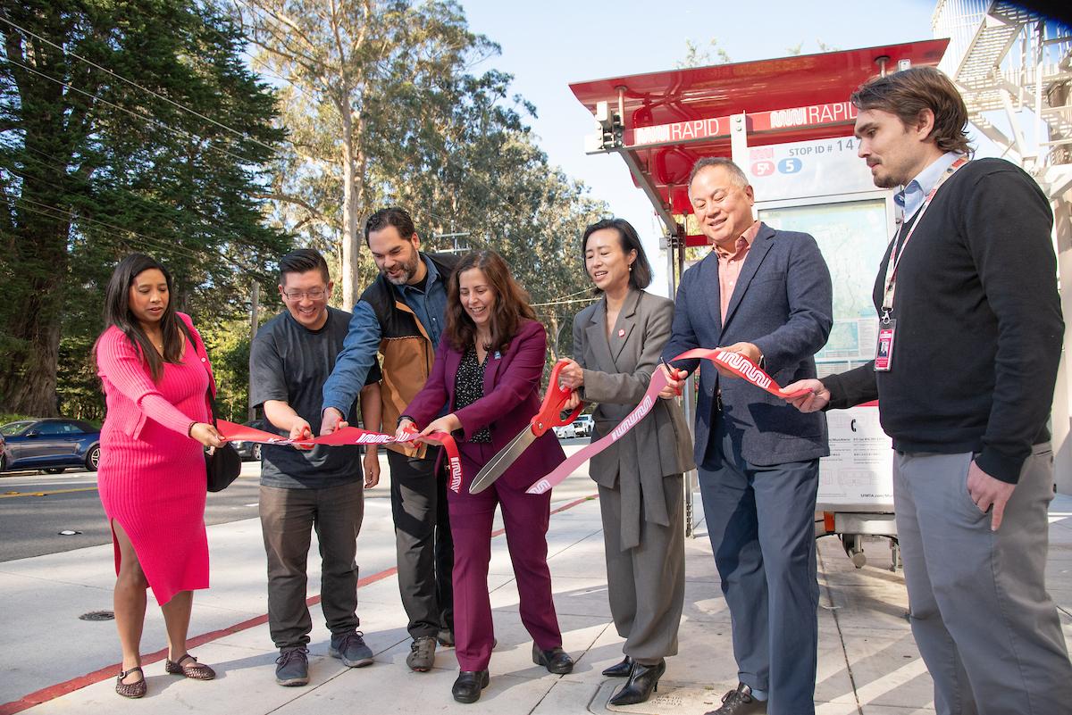 Several people cut a ribbon for the completion of the 5 Fulton Street Safety and Transit Project.