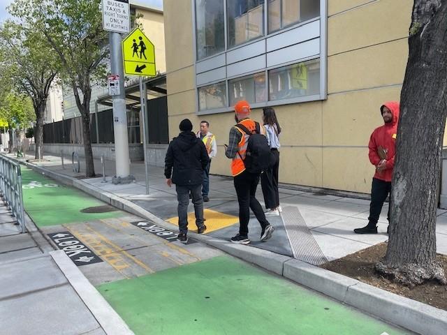 School walk audit takes places near a bikeway painted green. 
