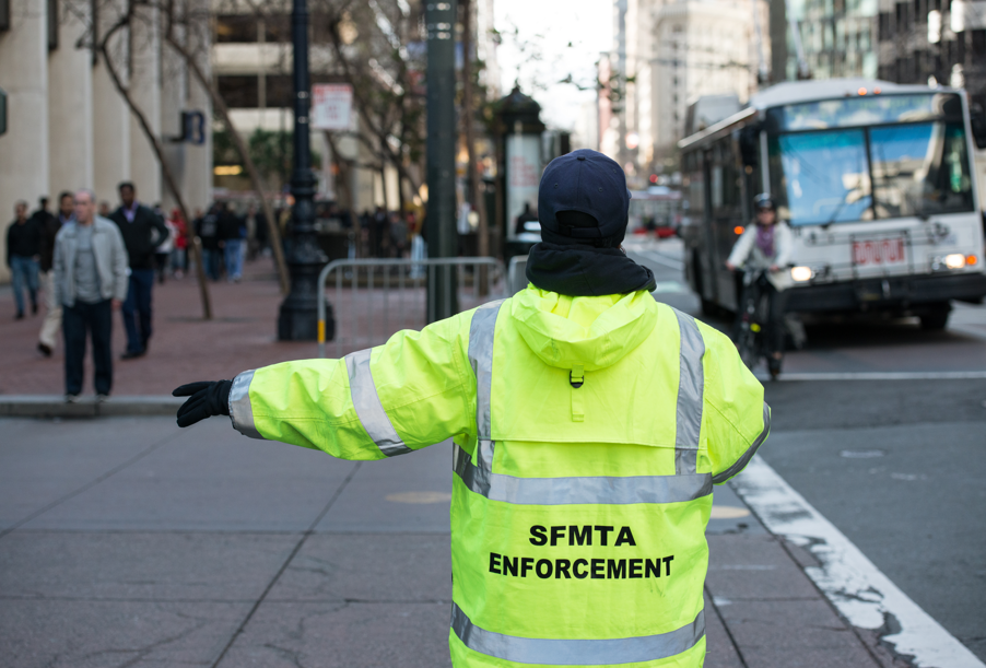 Market Street Closure. SFMTA Parking Enforcement Officer helps with traffic directing