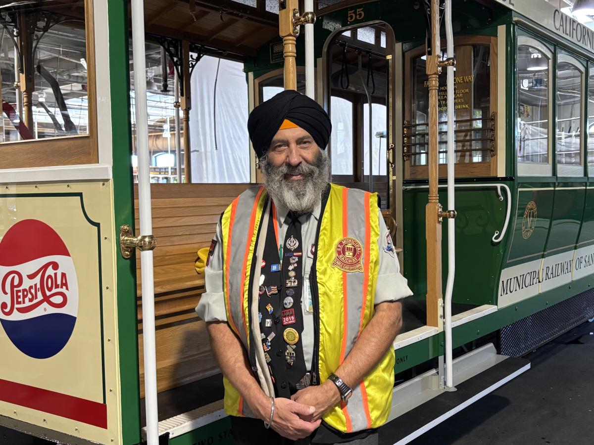 Cable Car Operator Singh Balraj Rai smiles near a vehicle. 