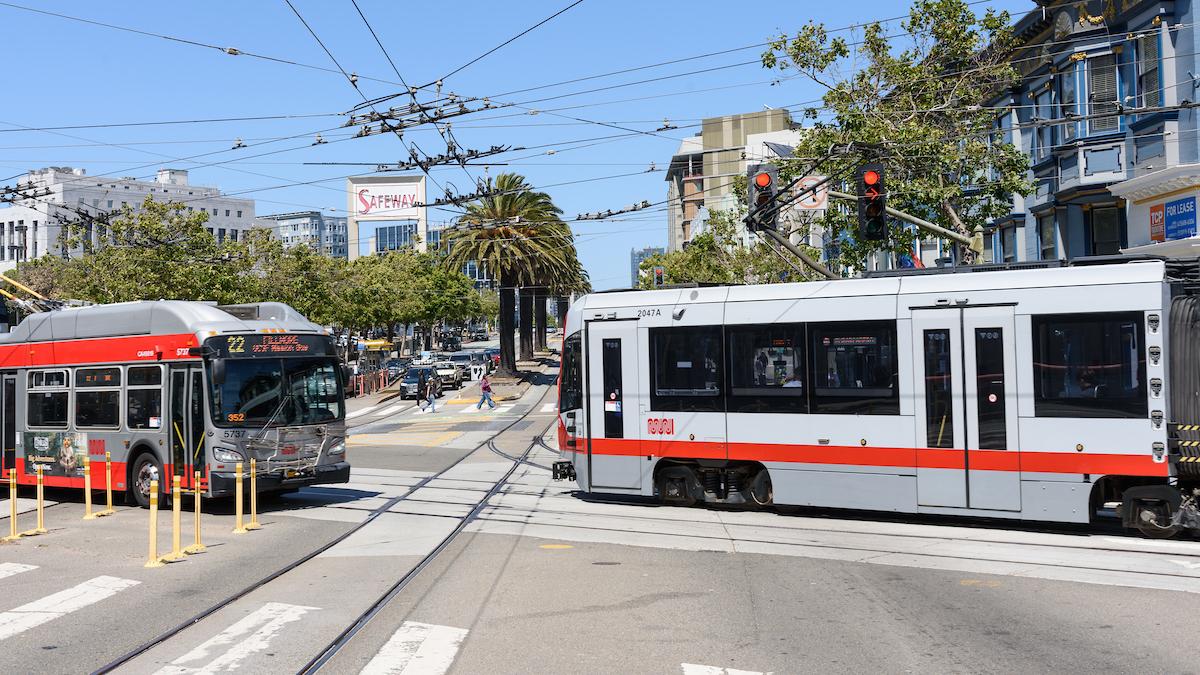 A bus and a train in an intersection.