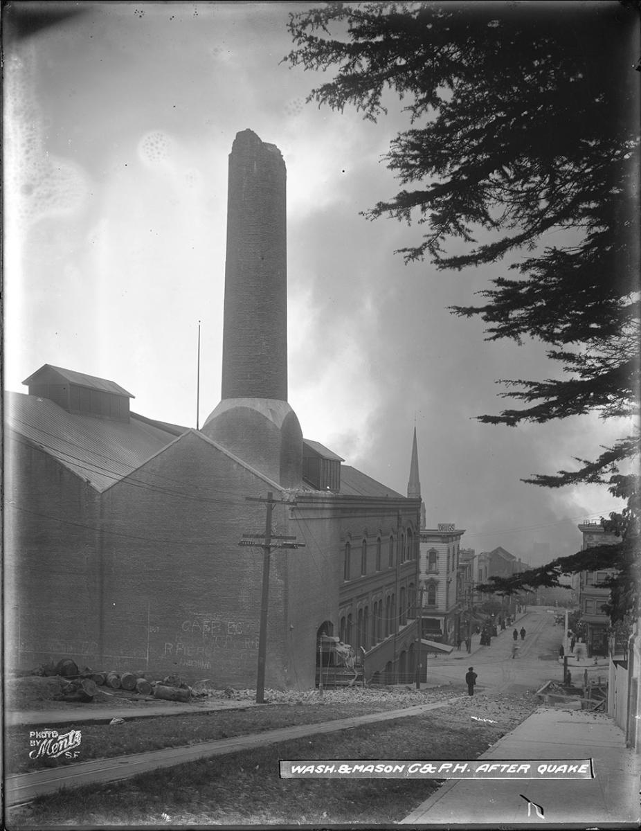  a building and road with smoke in the background. 