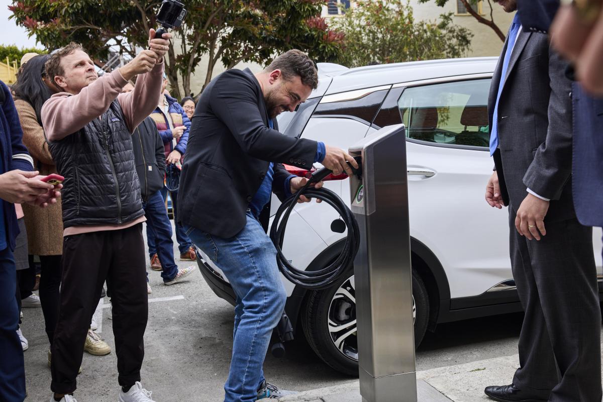 A person using a curbside charging station in Duboce Triangle in San Francisco. 