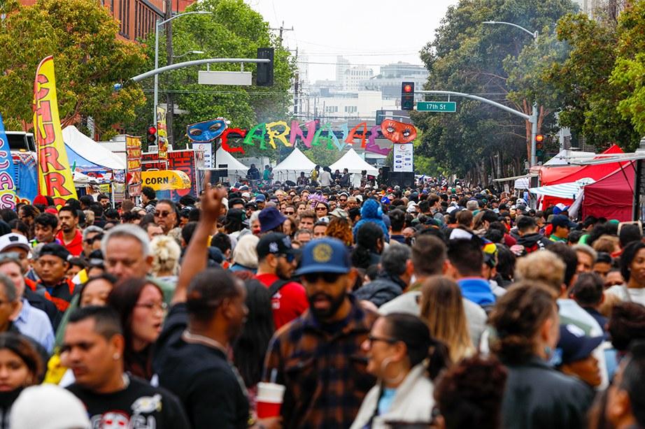 A street filled with people enjoying the Carnaval SF Festival.