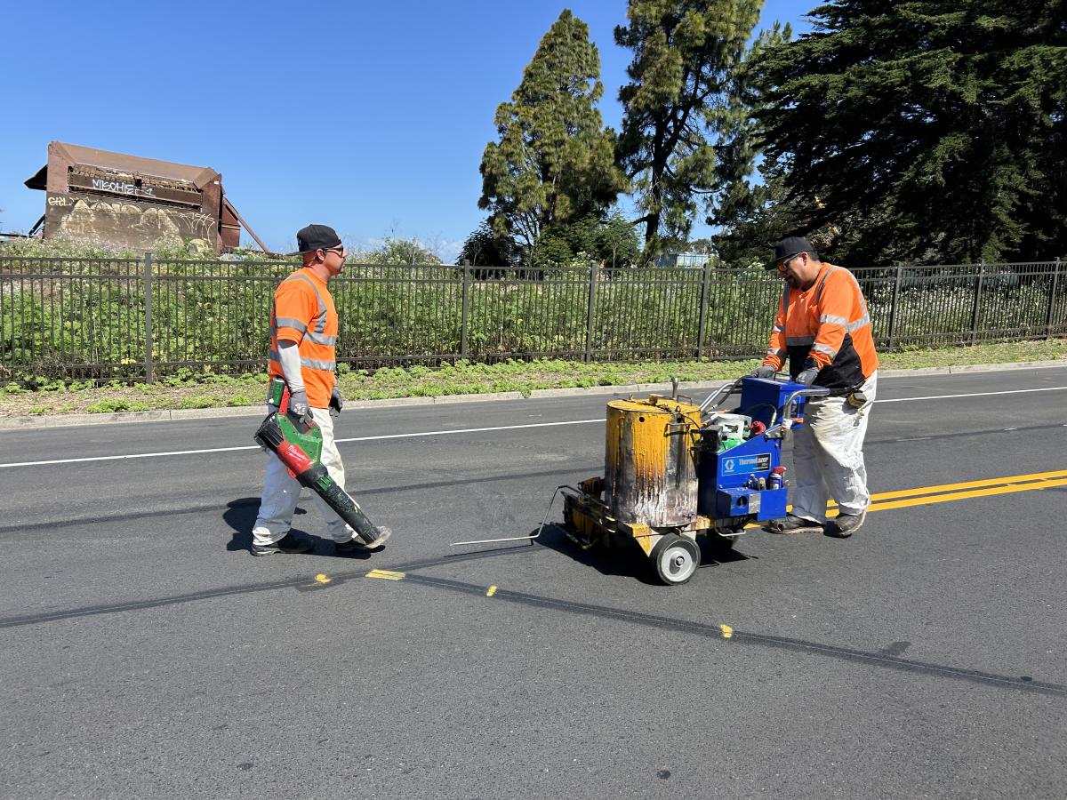 Crews paint double yellow lines on ground