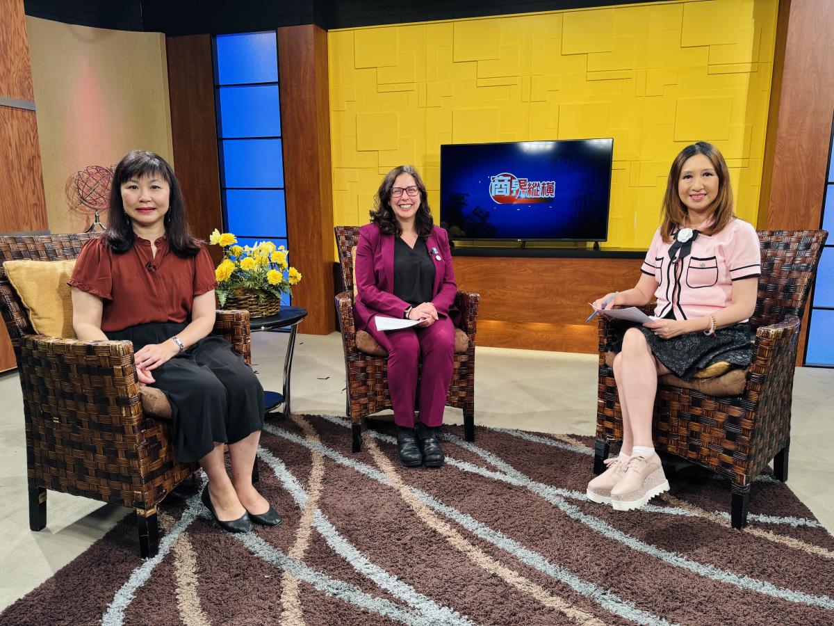 three women sit on chairs at a news station set