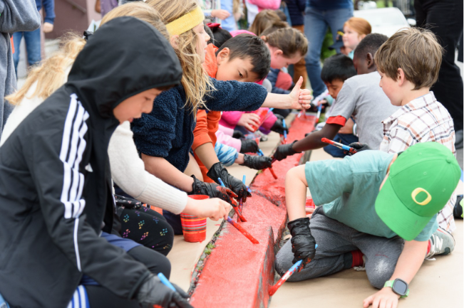 Students painting a curb red.