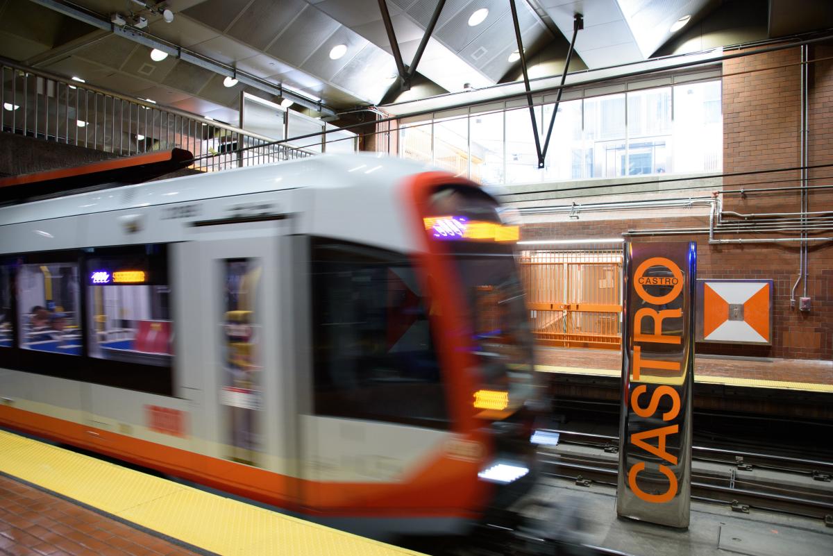 A train at a transit station with a sign that says “Castro” 