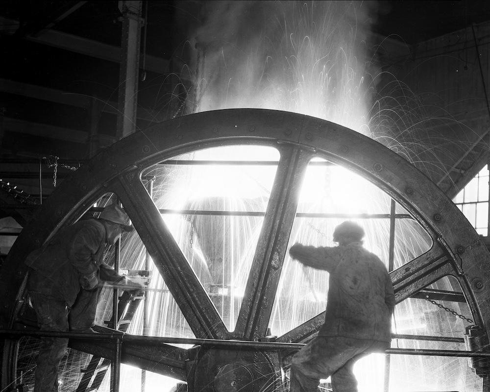 A person in front of a large wheel 