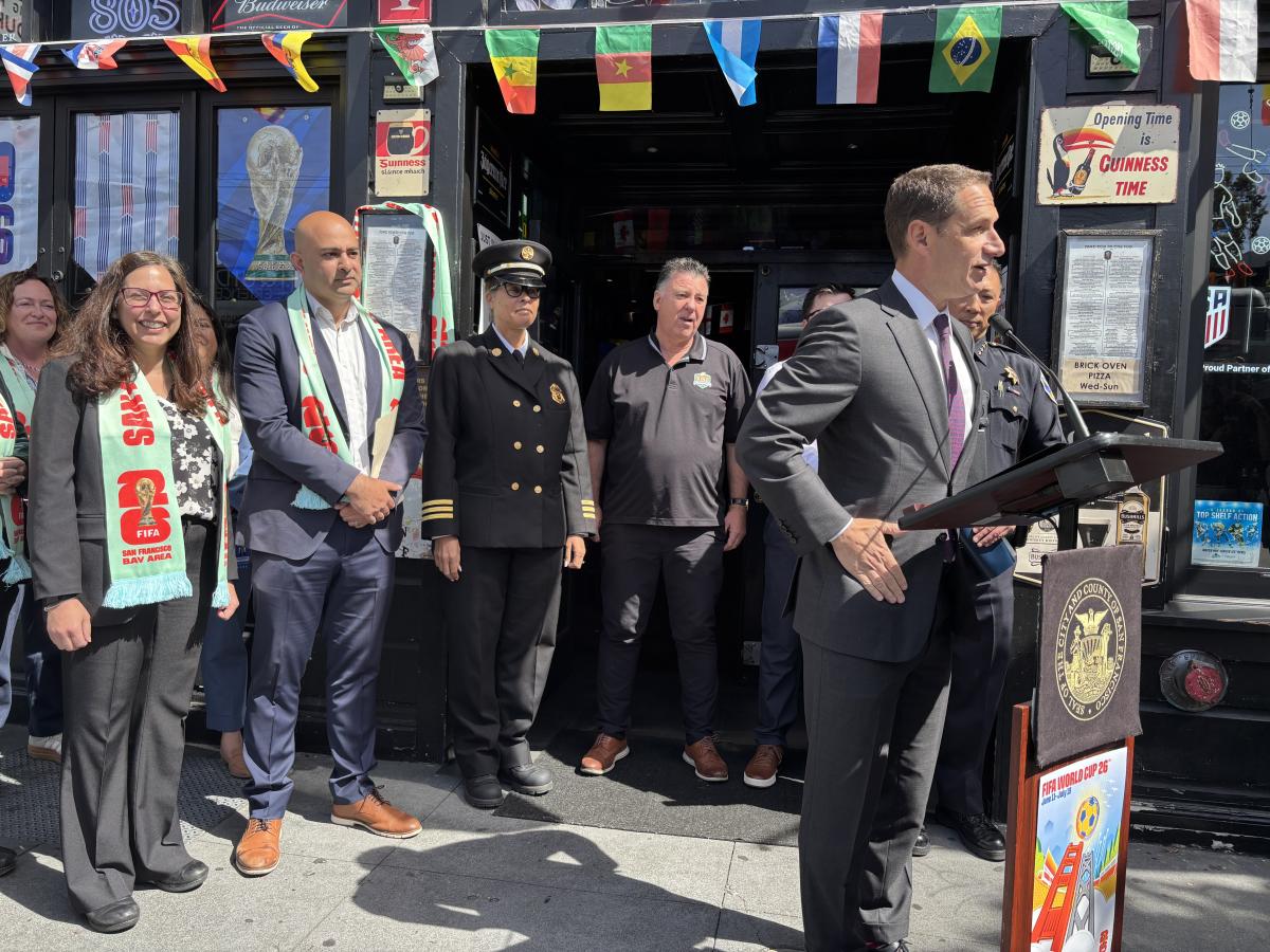 One person standing at a podium with several people behind him.  