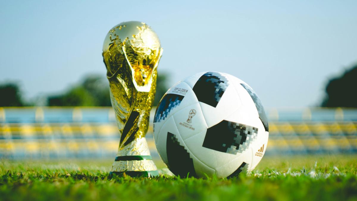 A ball and a trophy on grass. 
