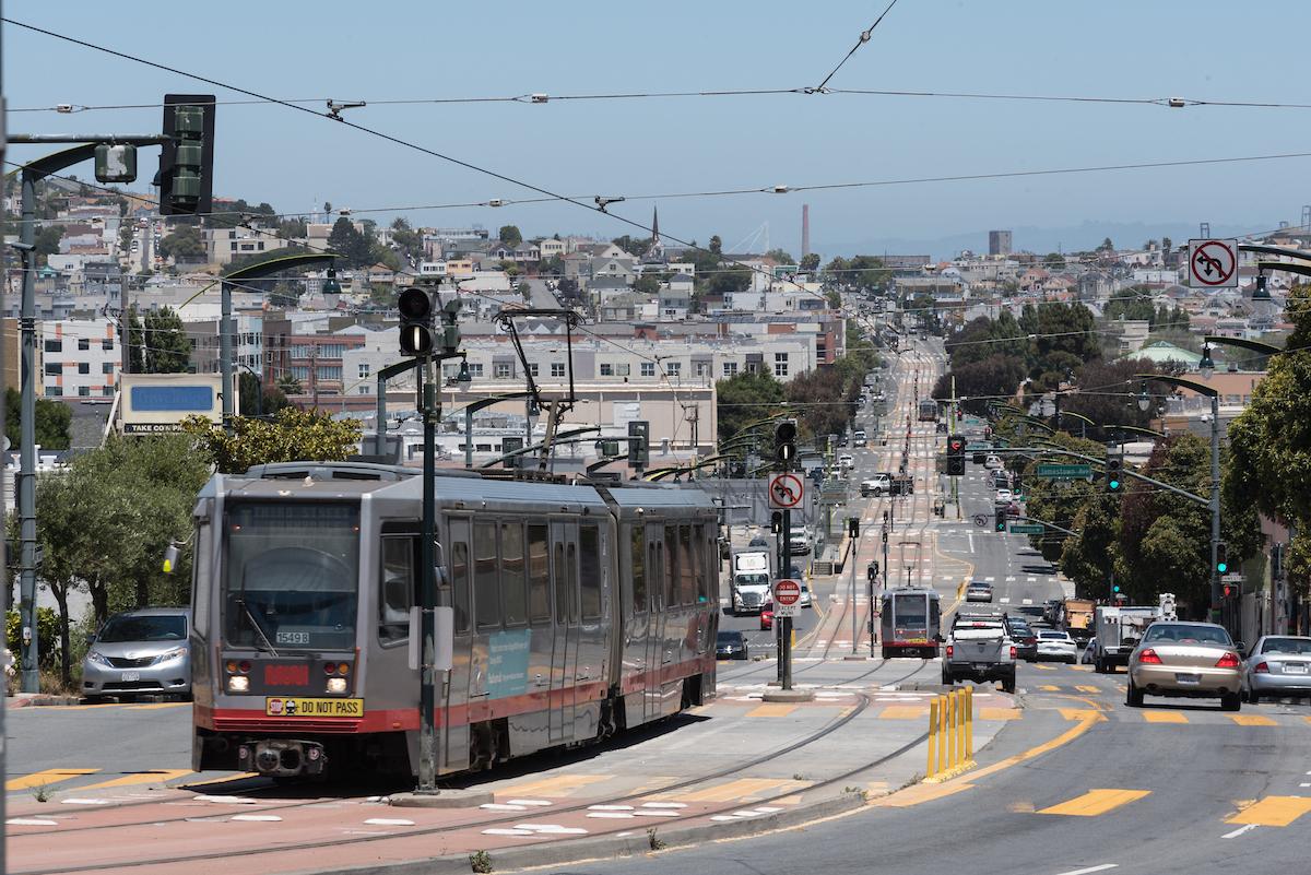 A train traveling down the middle of a street.