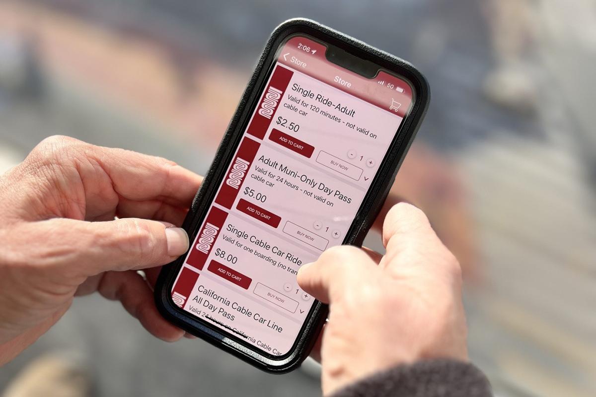Hands holding a phone with the MuniMobile app to buy Single-Ride Adult
