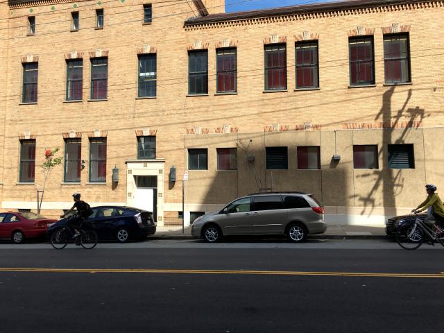 Two bicyclists riding along Bryant Street