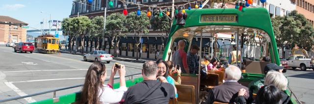 Riders on the open-topped boat style Blackpool streetcar on the Embarcadero