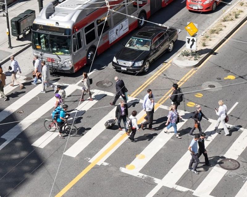 A bustling crosswalk, cars and Muni buses at Mission and 4th streets.