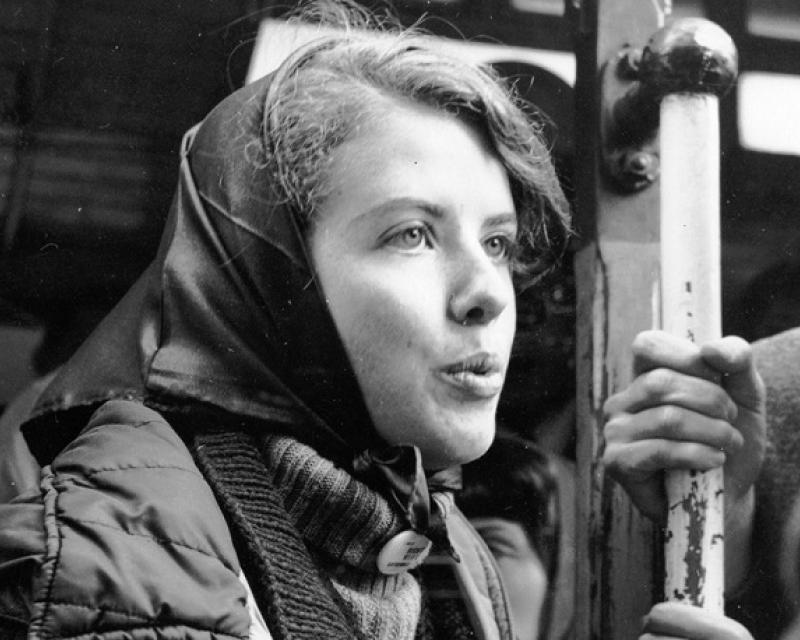 Mona Hutchins holding a pole while standing on a crowded cable car.