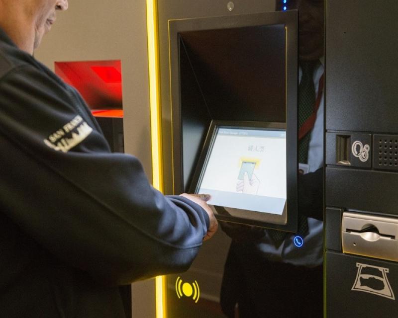 A man uses a touch screen for the new parking garage payment system.