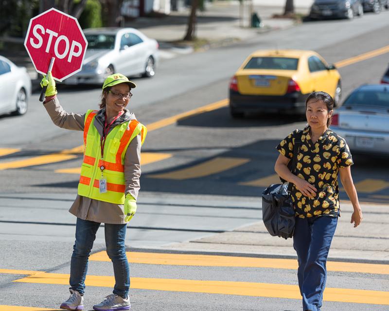 crossing guard helping pedestrians cross intersection