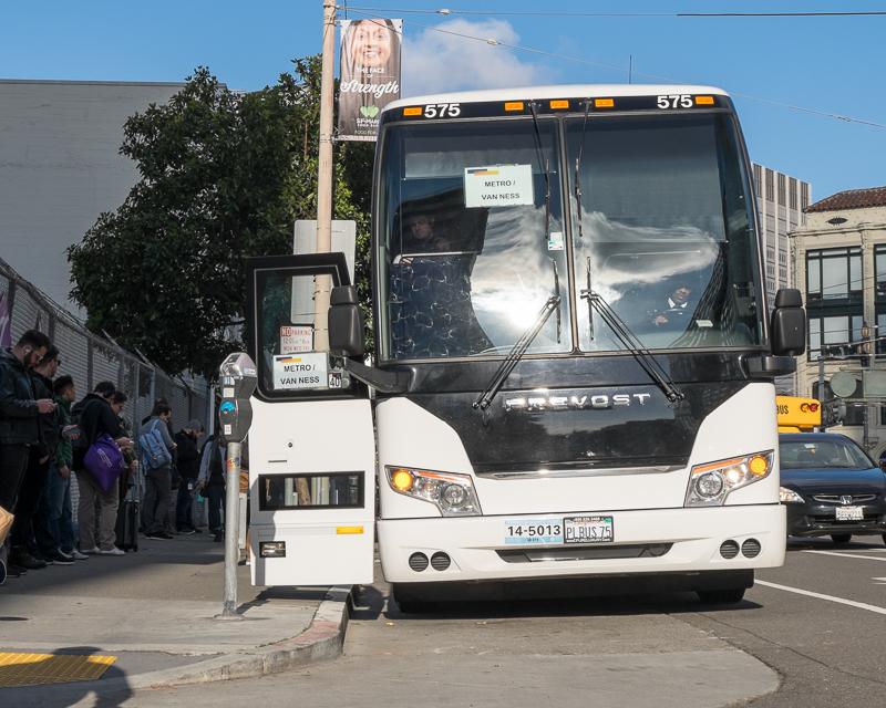 large private shuttle bus using curb space to load passengers