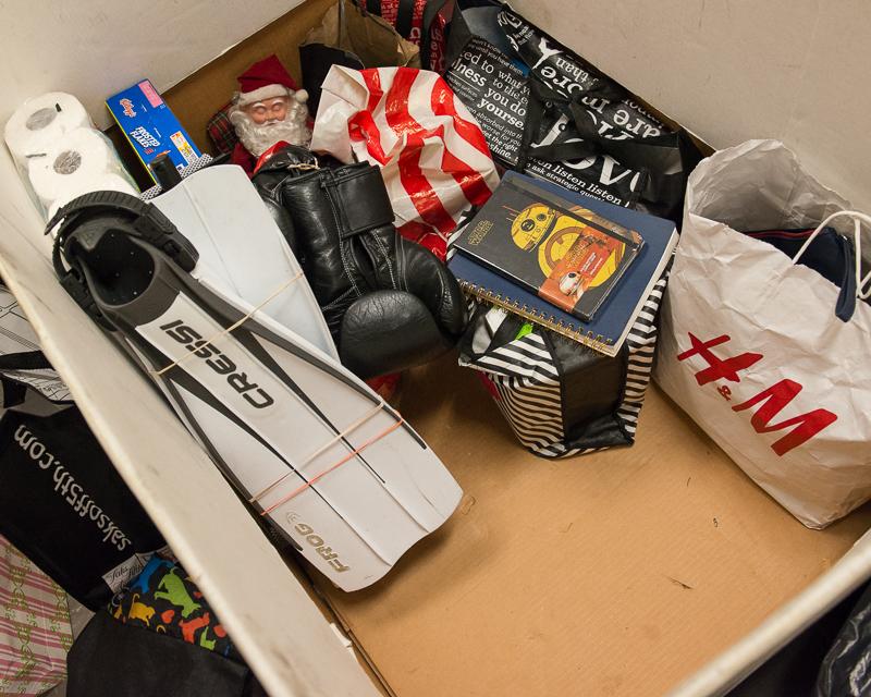 box filled with items lost on Muni.  Books, swimming flippers, Santa Claus doll, and bags