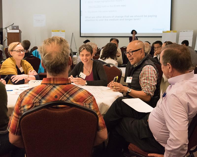 group of people sitting around table discussing something