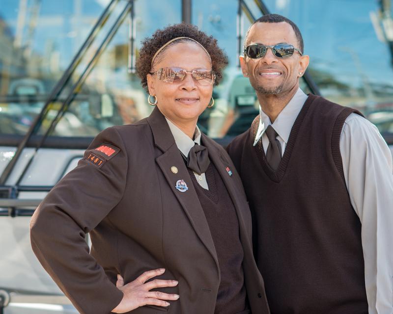 two operators standing in front of Muni bus